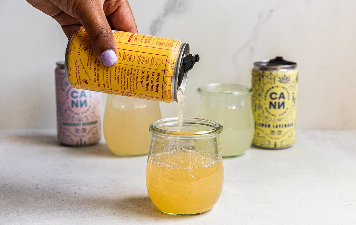 Person Pouring COntent from Yellow Can into Glass Person Pouring Content from Yellow Can into Glass